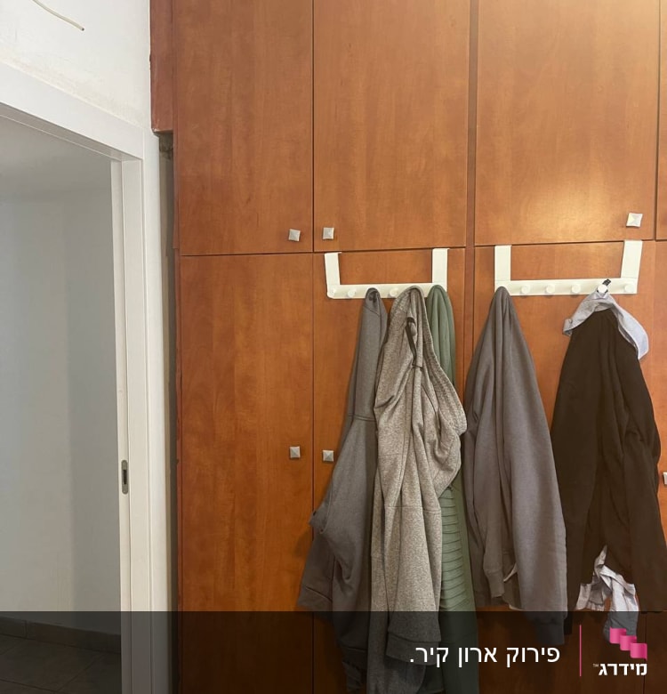 ארון עץ עם בגדים תלויים על מתלה